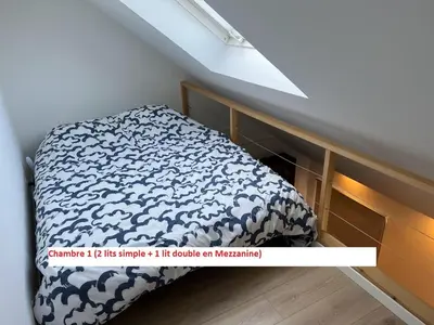 a bedroom with a bed with a white and blue comforter at Duplex sympa Verviers in Verviers