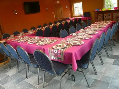 a long pink table with chairs and plates on it at Gîtes de Chevémont in Plombières