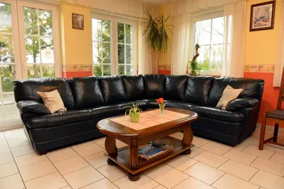 a black leather couch in a living room with a table at Gîtes de Chevémont in Plombières