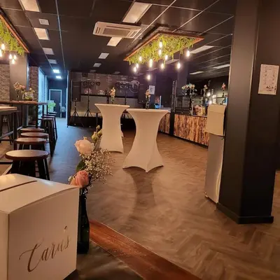 a restaurant with a bar with tables and chairs at Loogiez in Tongeren