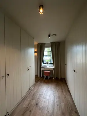 an empty room with white cabinets and a window at Het Herenhuis in Genk