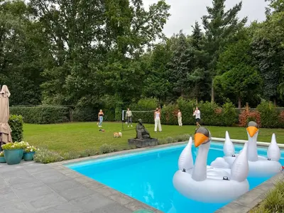 a group of people playing in a pool with swans at Het Herenhuis in Genk