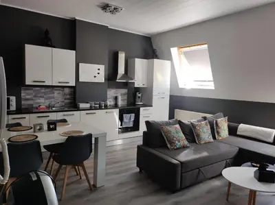 a living room with a couch and a kitchen at Escale in Liège