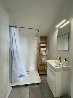 a white bathroom with a shower and a sink at St Catherine in Liège