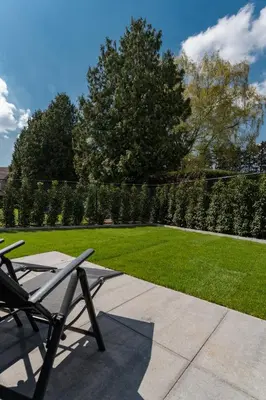 a patio with a chair and a grass yard at Luxury house 