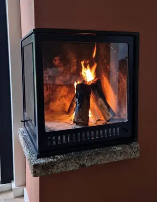 a fireplace with a fire in it at 't Bunga huiske in Lanaken