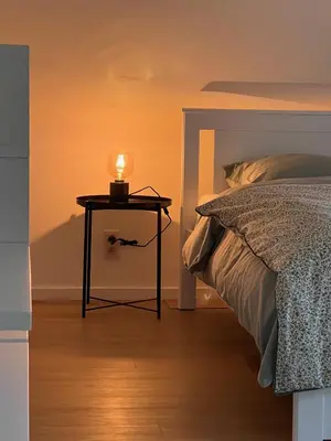 a small table with a candle on it next to a bed at De Bovenbuur in Lummen