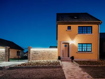 a yellow brick house with a door in front at Welldone Resort - Cozy Saxofoon in Nieuwerkerken