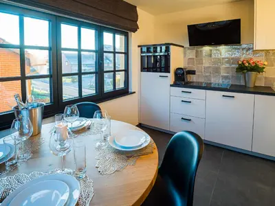 a kitchen with a wooden table with wine glasses on it at Welldone Resort - Cozy Saxofoon in Nieuwerkerken