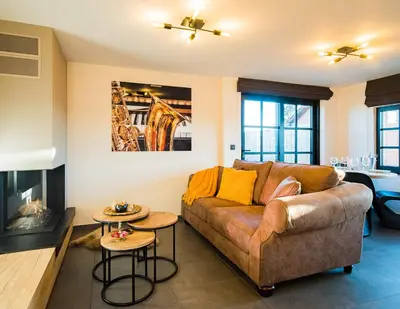 a living room with a couch and a fireplace at Welldone Resort - Cozy Saxofoon in Nieuwerkerken