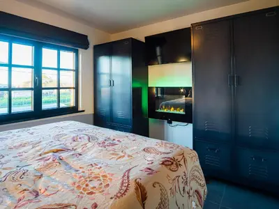 a bedroom with a bed and a fireplace at Welldone Resort - Cozy Saxofoon in Nieuwerkerken