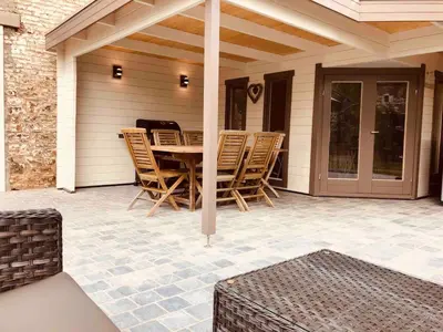 a patio with a table and chairs on a house at Jacuzzi - BBq - Jardin - Garden Lodge - Le Tulipier in Olne