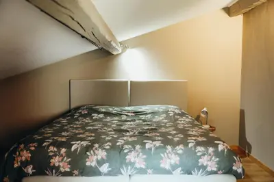 a bedroom with a bed with a floral bedspread at L'Orée du Bois by WelcHome in Verviers