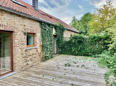 a brick building with a wooden walkway in front of it at Le Val du Cossart by WelcHome in Verviers