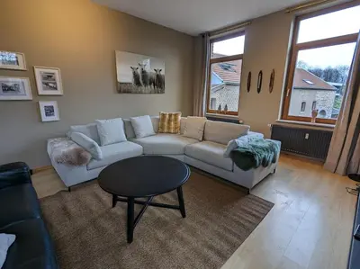 a living room with a couch and a table at Le Voisin du Pré by WelcHome in Verviers