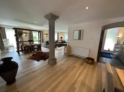 a large living room with a wood floor and a living room at Jacuzzi - Sauna - BBq - Jardin - Garden Lodge - Myosotis in Olne