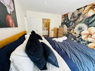 a bedroom with a blue and white bed with pillows at Jacuzzi - Sauna - BBq - Jardin - Garden Lodge - Myosotis in Olne
