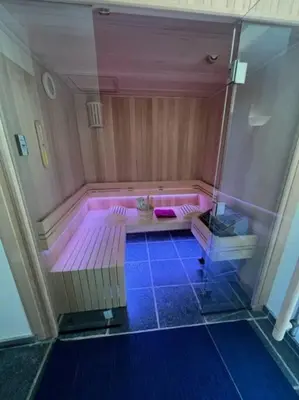 a pink bath tub with a purple floor in a room at Jacuzzi - Sauna - BBq - Jardin - Garden Lodge - Myosotis in Olne