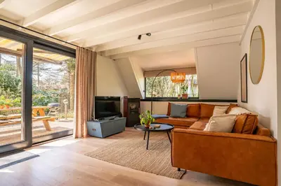 a living room with a couch and a tv at Boshuisje Rekem - Topo in Lanaken