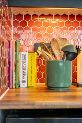 a green pot sitting on a shelf with books at Boshuisje Rekem - Topo in Lanaken