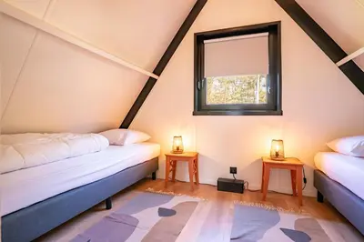 two beds in a room with a window at Boshuisje Rekem - Topo in Lanaken