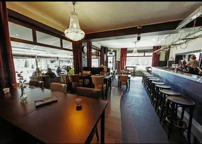 a restaurant with tables and chairs and a bar at Homestay La Montagne des Coeurs in Eigenbilzen