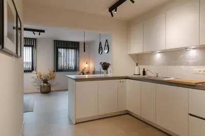 a kitchen with white cabinets and a counter top at Bij de secretaris in Kanne