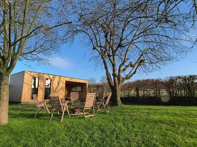 a tiny house sitting in the middle of a field at Bij de secretaris in Kanne