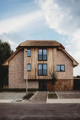 a brick house with windows on a street at Eikenhoef in Lommel