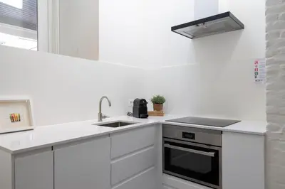 a white kitchen with a sink and a stove at Huys17 in Hasselt