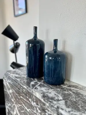 two blue glass vases sitting on top of a table at Bellevue - Grand appartement pour 5 sur les quais de la Meuse in Liège