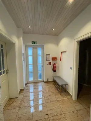 an empty hallway with a bench and a door at Apart Loten in Eupen