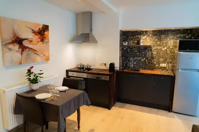 a kitchen with a table and a refrigerator at Cheval Blanc - Holiday Rental in Aubel