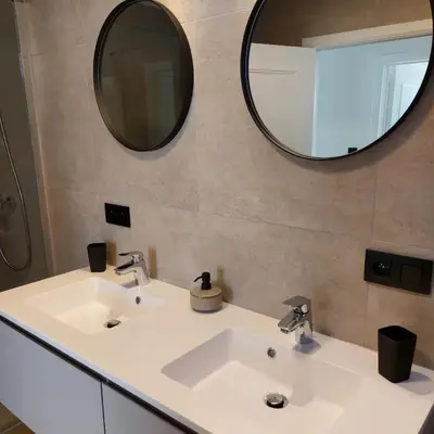 a bathroom with two sinks and a mirror at Vakantiewoning De Papendaler in Zutendaal