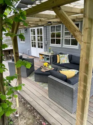 a patio with a blue couch on a wooden deck at Chalet Sint-Hubertus Du Bois in Zutendaal