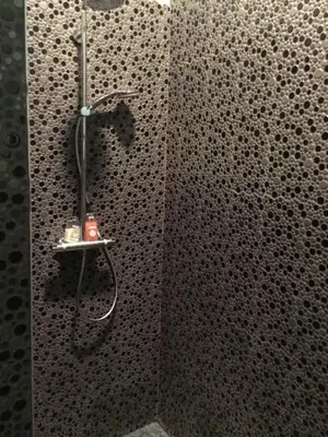 a shower in a bathroom with black and white tiles at B&B AntiQua & Qook in Tongeren