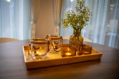 a wooden tray with candles and a vase with flowers at Chalet Het Edelhert in Zutendaal