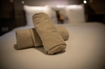 two rolled up towels sitting on top of a bed at Chalet Het Edelhert in Zutendaal