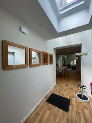a room with three mirrors on a wall with a table at Maison 4 chambres avec jardin in Liège
