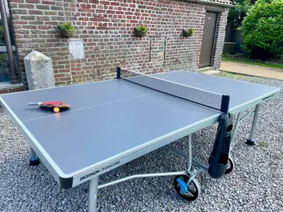 a ping pong table in front of a brick wall at Gite Pays de Herve - Emeraude in Battice