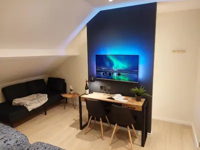 a living room with a desk and a couch at Viator Holidayhome in Tongeren