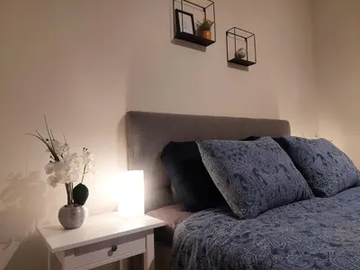 a bedroom with a bed and a table with a lamp at Viator Holidayhome in Tongeren