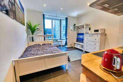 a small bedroom with a bed and a kitchen at Studio Hyper centre - Cathédrale in Liège