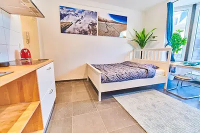 a small bedroom with a bed and a kitchen at Studio Hyper centre - Cathédrale in Liège
