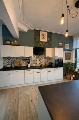 a kitchen with white cabinets and a counter top at Duplex dans le centre d'Heusy in Verviers