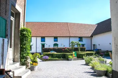 a courtyard with plants and flowers in front of a building at B&B De Oude Winning in Riemst