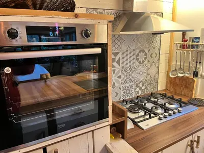 a kitchen with a stove top oven in a kitchen at Vakantiechalet voor 4 plus 2 met sauna in Lanaken