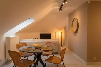 a dining room with a table and chairs and a bed at Trudo Loft in Sint-Truiden