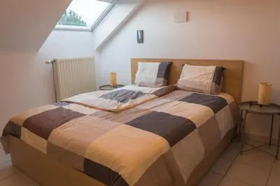 a large bed in a room with a window at Trudo Loft in Sint-Truiden