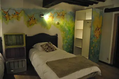a bedroom with a bed with a painting on the wall at Le Chat Roi - Charneux in Herve
